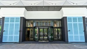 A modern building entrance with a revolving door, glass doors, and a geometric ceiling design. - Hangzhou Chengbei Relax Hotel (Hangzhou)