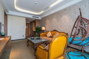 Um saguão de hotel com uma recepção, um sofá, uma cadeira suspensa e um abajur.