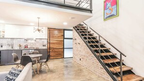 A modern kitchen with a dining area, a staircase, and a mural. - Loft 302 Summary:<br>We (Puerto Vallarta)
