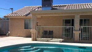Una propiedad residencial con piscina, techo de tejas y patio amurallado.