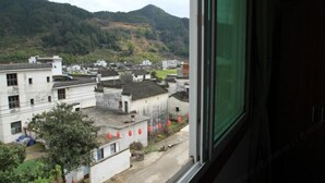 Un pittoresco villaggio tradizionale con edifici bianchi e una montagna sullo sfondo.