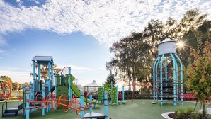 A playground with various play structures, including a climbing frame, slides, and swings. - Lake house retreat. (Inverness)