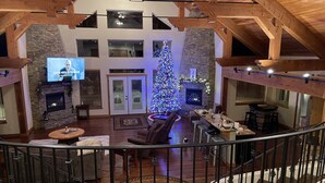 A spacious living area with a high ceiling, stone fireplace, and a large Christmas tree. - Beautiful home on the 10th green on Priest Lake Golf Course (Priest Lake)