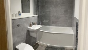 Ein modernes Badezimmer mit Badewanne, Waschbecken und Toilette.