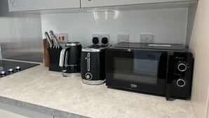Eine Küche mit Kaffeemaschine, Toaster und Mikrowelle.