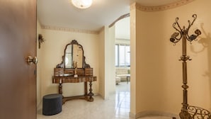 A room with a wooden vanity, a mirror, a decorative metal stand, and a tiled floor. - GuestHost - Grazia Attic Apartment with terrace (Trani)