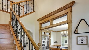 A wooden staircase with black balusters leading to a mirrored room.
