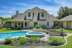 A two-story house with a backyard featuring a swimming pool, a hot tub, and outdoor seating. - Game room, 16 Beds, Pool, Hot tub, 12 min to Downtown (Manchaca)