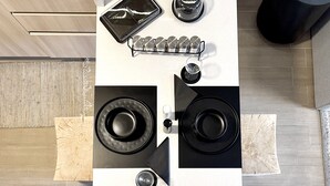A kitchen with a white countertop, black appliances, and a wooden floor.