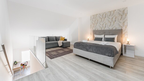 Un dormitorio moderno con una cama grande, un sofá y un escritorio.
