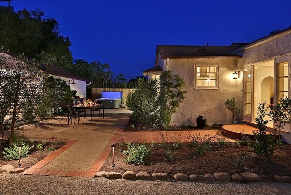 Enjoy a serene garden setting with a patio and outdoor furniture.