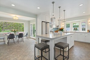 Enjoy cooking in this kitchen with a spacious island, bar stools, and ample counter space.
