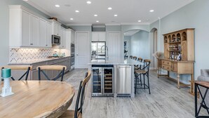 Una cocina moderna con armarios blancos, electrodomésticos de acero inoxidable y una isla central.