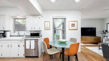 Een koffiezetapparaat/waterkoker, kookgerei, borden en bestek