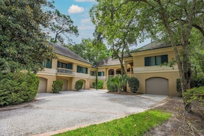 A two-story building with a covered driveway and a courtyard.