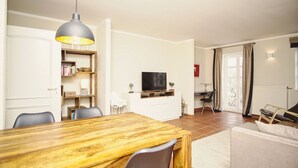 Ein modernes Wohnzimmer mit einem Holzesstisch, einem Fernseher und einem Bücherregal.