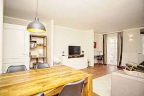 Ein modernes Wohnzimmer mit einem Holzesstisch, einem Fernseher und einem Bücherregal.
