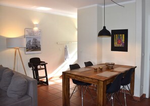 Ein Essbereich mit Holztisch, Stühlen und einer hängenden Pendelleuchte.