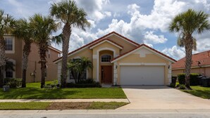 A residential house with a garage, palm trees, and a clear sky. - Aviana resort near Disney, private pool, WiFi, washer, dryer, gameroom (Davenport)