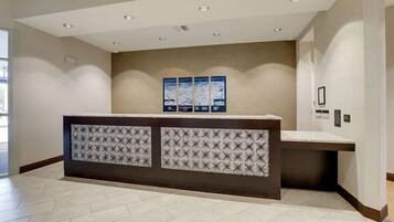 A reception area with a patterned counter, a wall-mounted map, and recessed ceiling lights.