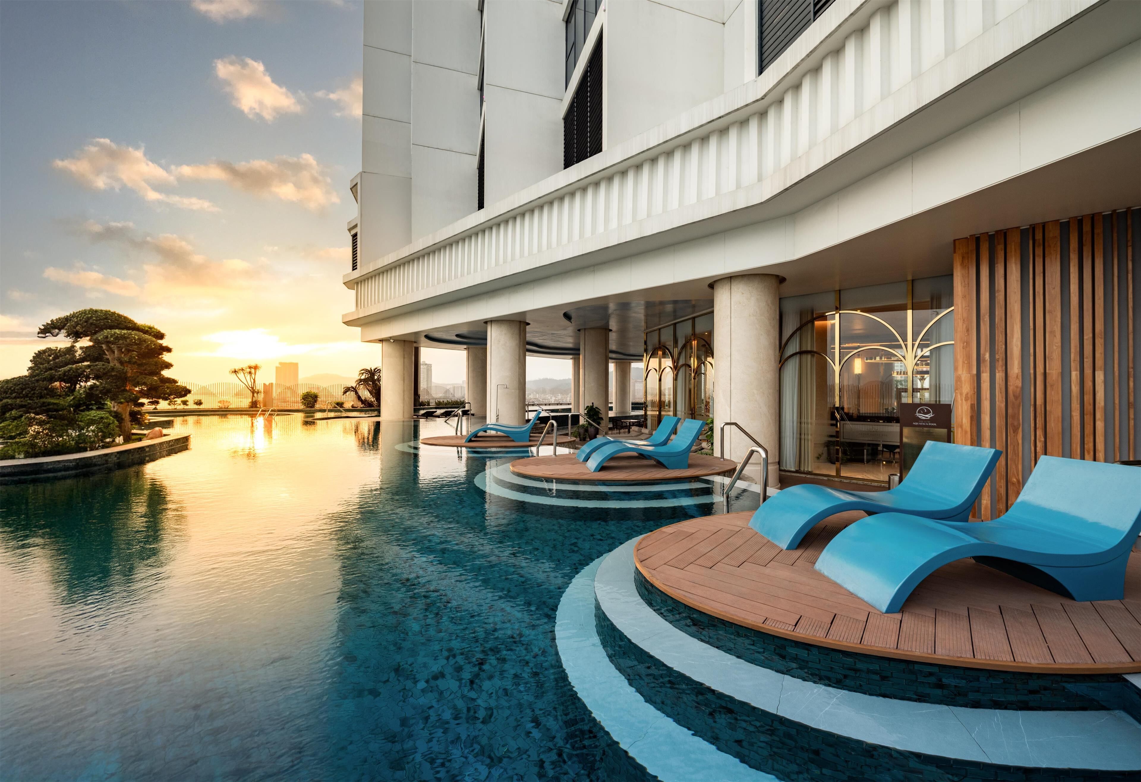 Een binnenzwembad, een buitenzwembad en parasols bij het zwembad