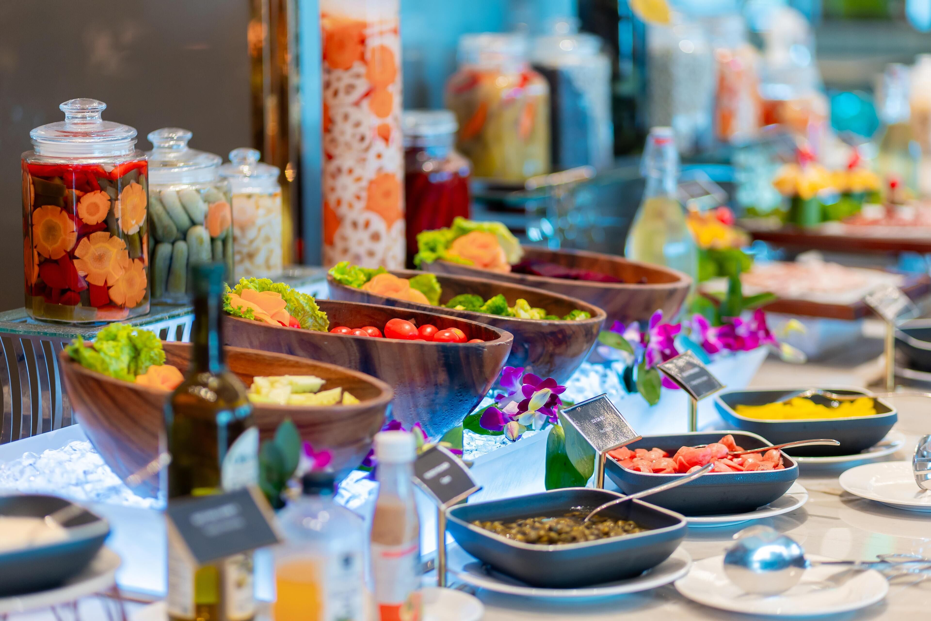 A buffet with various food items and condiments.