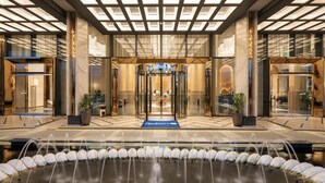 A hotel entrance with a glass door, a blue carpet, and a water feature in front. - Radisson Blu Hotel, Ha Long Bay (Bai Chay)