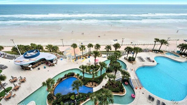 Ein Resort mit großzügiger Poolanlage, einem Strand und einer Bar.