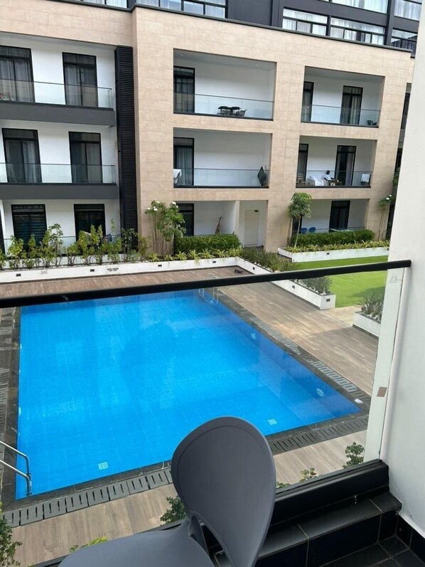 Un edificio moderno con piscina, balcones y vistas del entorno.