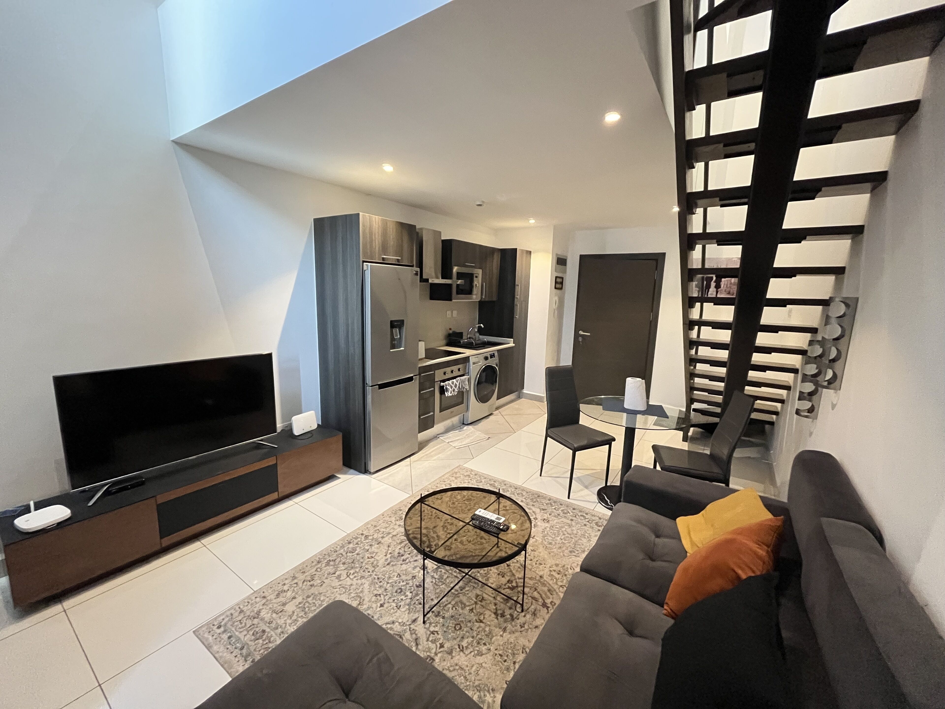 Een modern appartement met een woonkamer, keuken en eetgedeelte.