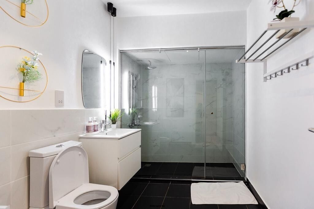 A modern bathroom with a toilet, sink, and shower.