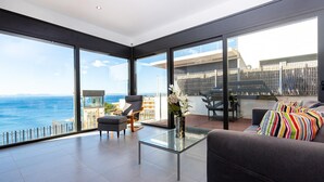 A modern living room with a glass coffee table, a sofa, and a chair, overlooking a scenic ocean view. - Villa on Almadrava beach, Roses. Private parking, 200m beach, 3 bedrooms, equipped kitchen, terrace, Wi-Fi, air conditioning. Book now for an unforgettable holiday on the Costa Brava! (Roses)