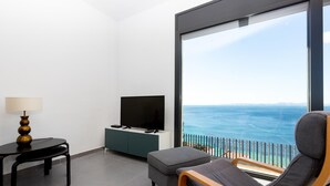 A balcony with a view of the ocean, a TV on a cabinet, a lamp, and a chair. - Villa on Almadrava beach, Roses. Private parking, 200m beach, 3 bedrooms, equipped kitchen, terrace, Wi-Fi, air conditioning. Book now for an unforgettable holiday on the Costa Brava! (Roses)