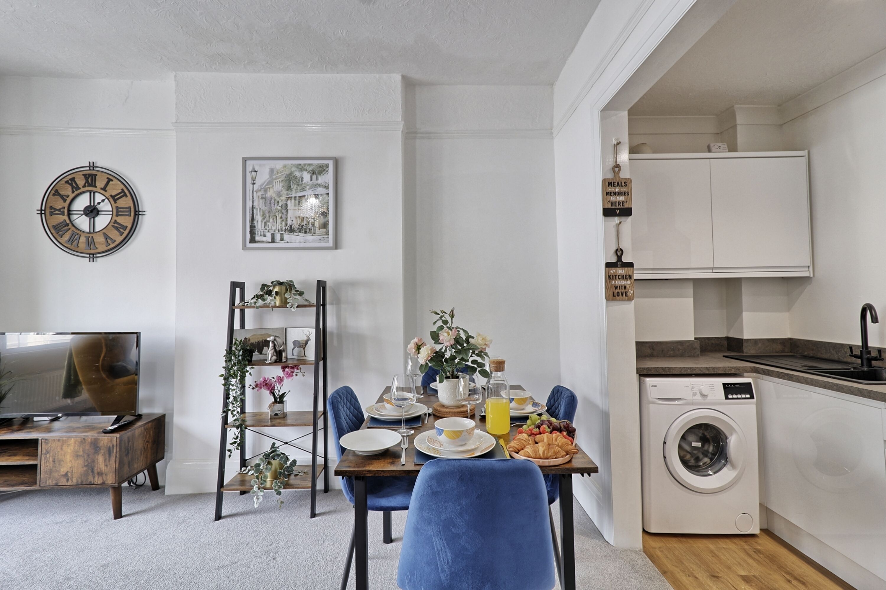 Un espace de vie compact comprenant un coin repas, un lave-linge et une cuisine.