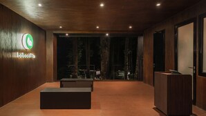 Una moderna zona de recepción con interior de madera, un mostrador de recepción y un logotipo en la pared.