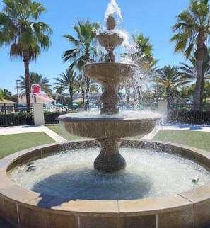 A multi-tiered fountain with water cascading down its center, surrounded by a circular stone basin.