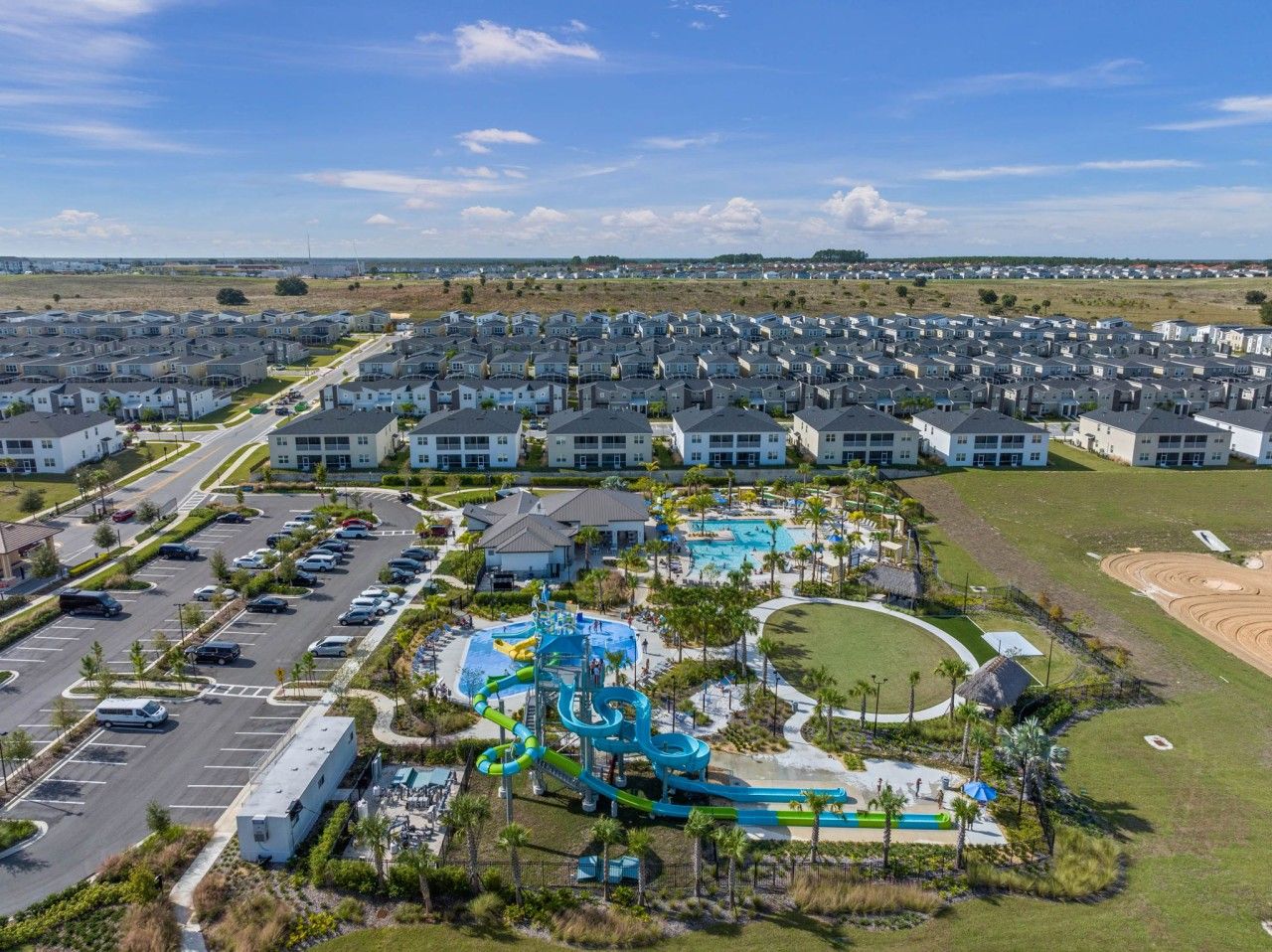 A residential area with multiple apartment buildings, a parking lot, and a water park with slides and pools.