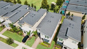Ein Wohngebiet mit mehreren zweistöckigen Häusern, jedes mit einer Garage und einem kleinen Vorgarten.