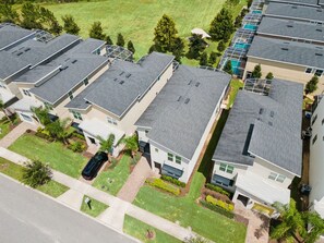 Una zona residenziale con diverse case a due piani, ciascuna con garage e un piccolo giardino antistante.
