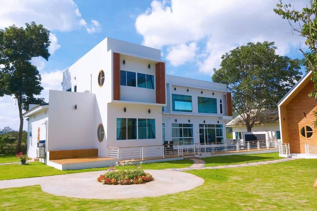 A modern two-story building with large windows and a well-maintained lawn.