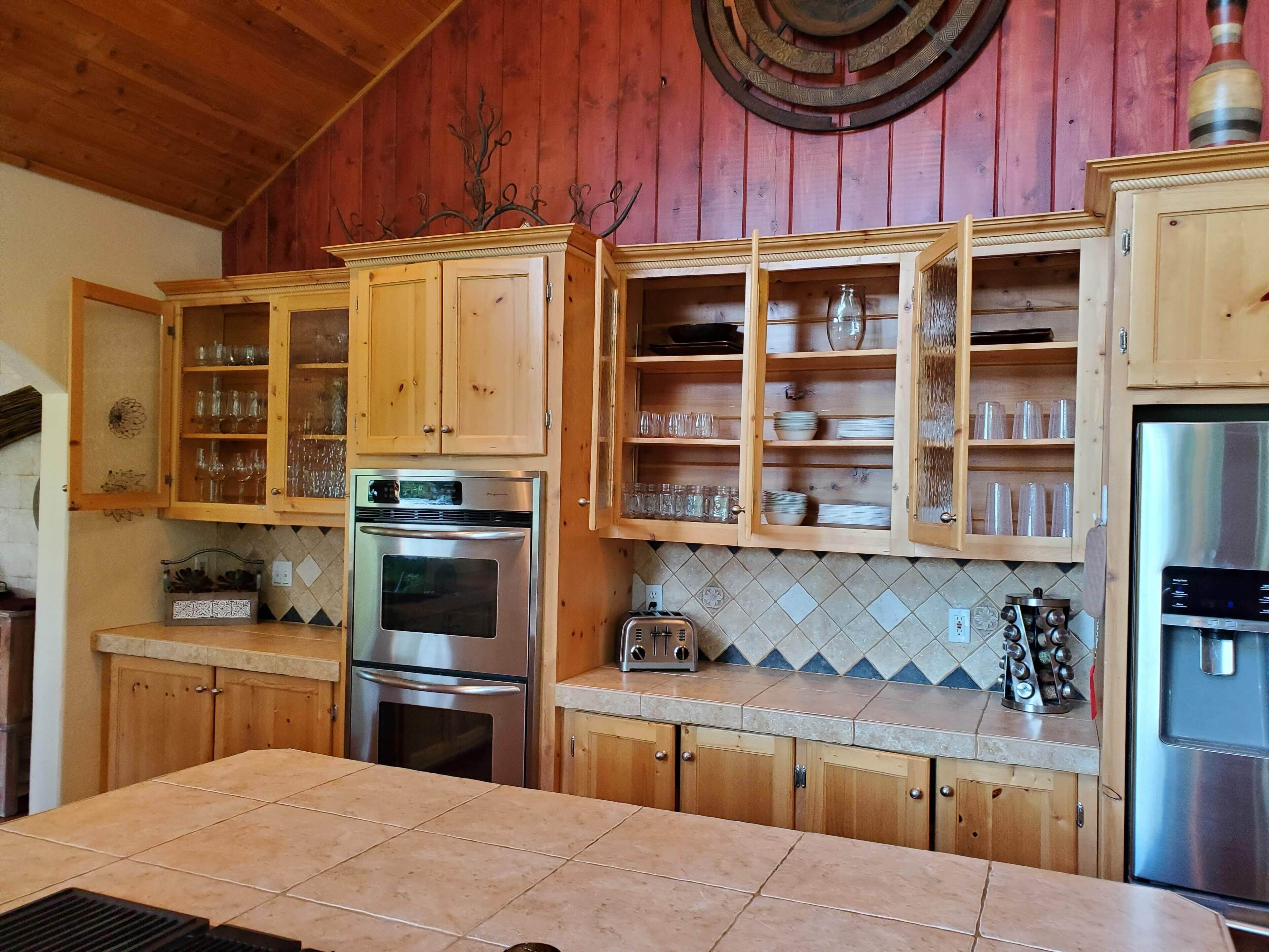 A kitchen with wooden cabinets, a stainless steel oven, and a refrigerator.