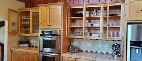 A kitchen with wooden cabinets, a stainless steel oven, and a refrigerator.
