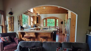 Une cuisine moderne avec des meubles en bois, un îlot central et une vue sur l’extérieur.