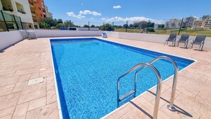 A rectangular swimming pool with a tiled edge, surrounded by a tiled deck. - Seaside Heaven Apartment (Larnaca)
