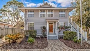 A two-story house with a front porch, a wooden fence, and a brick driveway. - 7BR Family Oasis | Heated Pool + Walk to Beach (North Myrtle Beach)