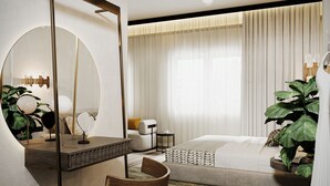 A modern bedroom with a large bed, a round mirror, a wooden side table, and a green ottoman. - The Parrs Bank Hotel  (Warrington)