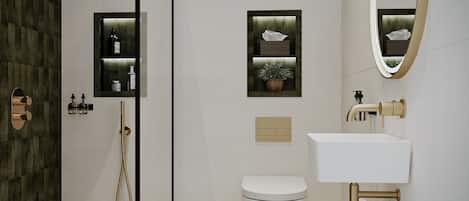 A modern bathroom with a glass-enclosed shower, a white toilet, a sink with a gold faucet, and a wooden stool.