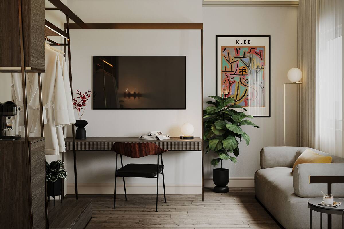 A modern living room with a flat-screen TV, a sofa, a coffee table, a plant, and a wooden floor.
