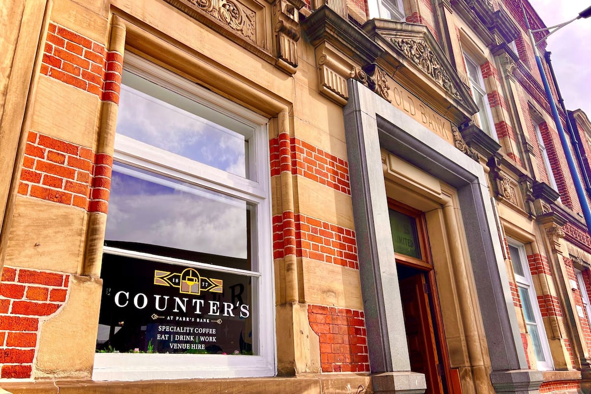 A building facade with a window displaying a coffee shop named 'COUNTER'S' offering specialty coffee, eat, drink, work, and venue hire.