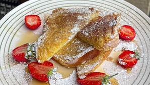 A plate of bread pudding with strawberries and syrup, served on a striped plate. - The Parrs Bank Hotel  (Warrington)